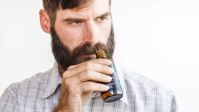 man with beard smelling natural aftershave